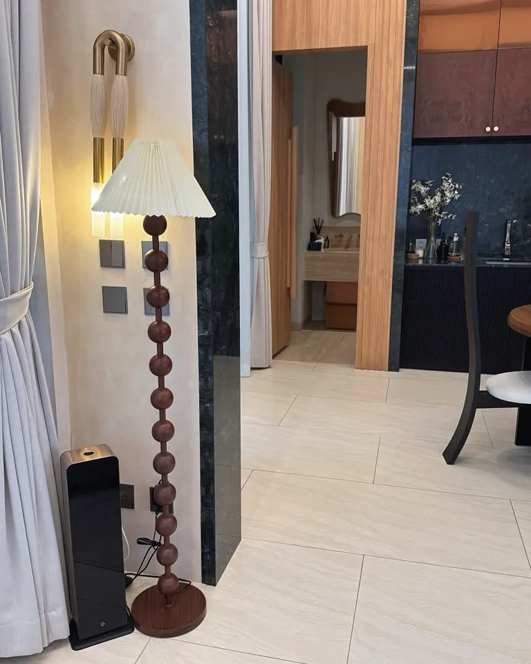 Black tower scent diffuser next to a floor lamp in a condominium living room