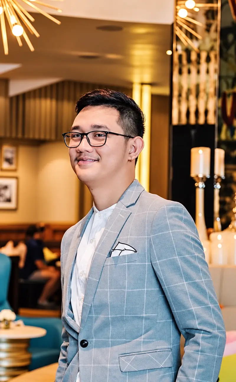 Jovani Ejercito, COO of Scent Up Thailand, in glasses and a light blue checked blazer